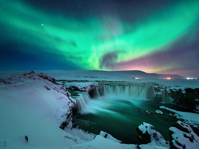 A stunning aurora shape like phoenix bird appears above the landscape of Godafoss water fall in winter Iceland