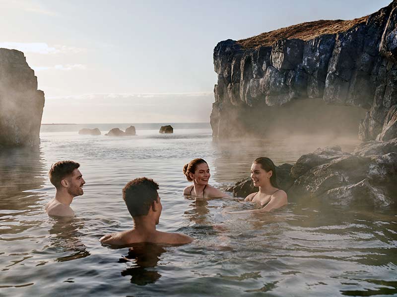 4 people bathe and enjoy themselves in the Sky Lagoon