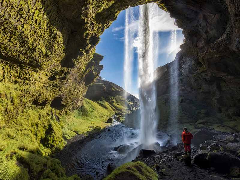 Hiker at Majestic Kvernufoss Waterfall in Iceland