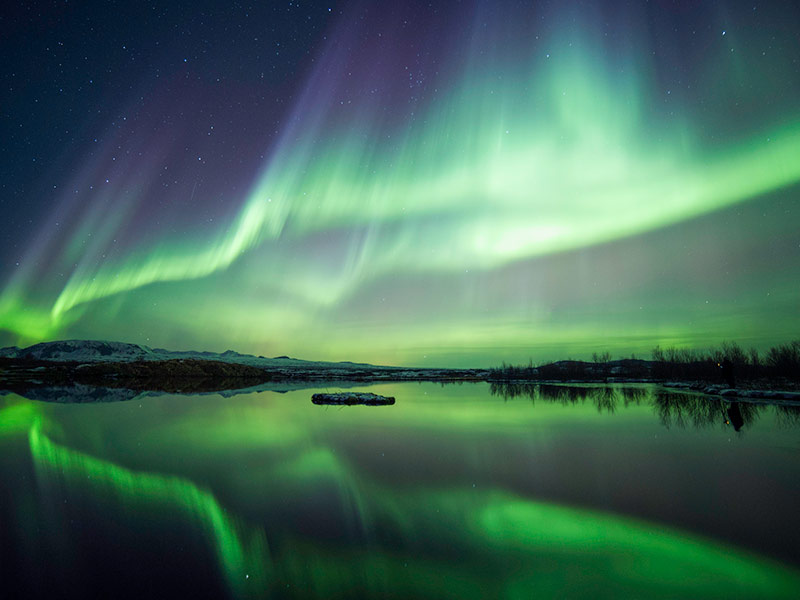 Northern lights blazing over lake Thingvellir national park in Iceland
