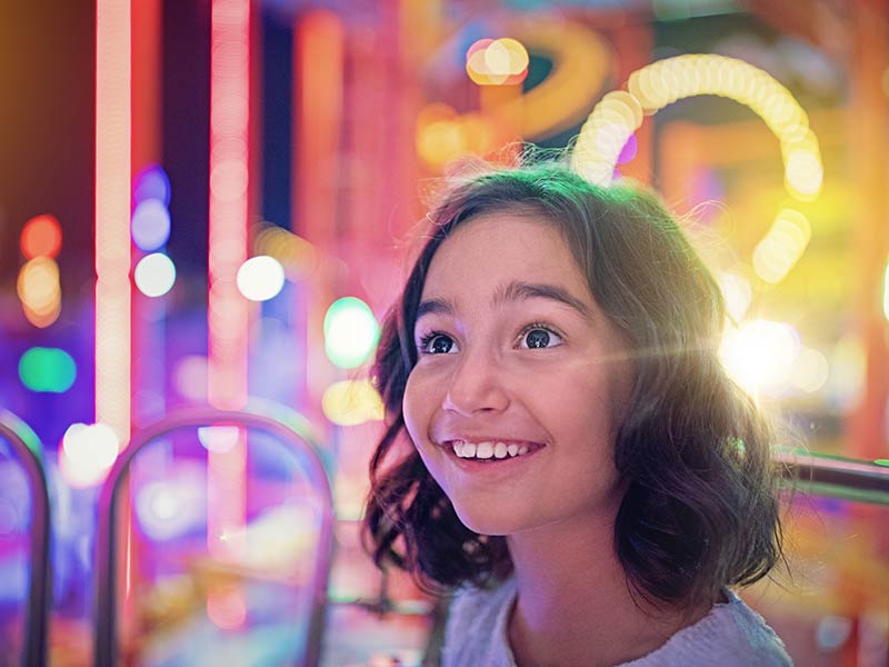 Happy girl is smiling on ferris wheel in an amusement park
